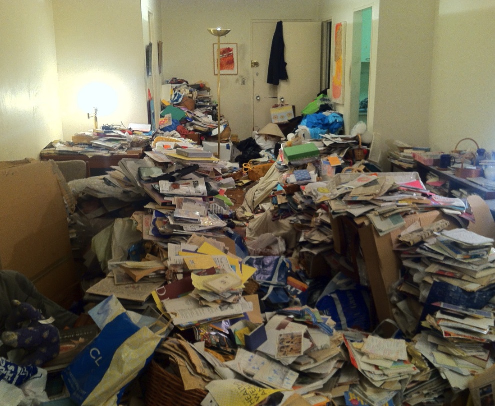 Paper-heavy apartment room before Wixom clutter removal